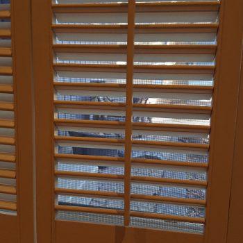 Indoor Wooden Shutters With Mesh Screen And Outdoors
